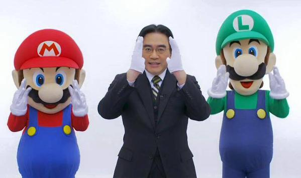 Satoru Iwata between the two most characteristic video game figures, Mario and Luigi